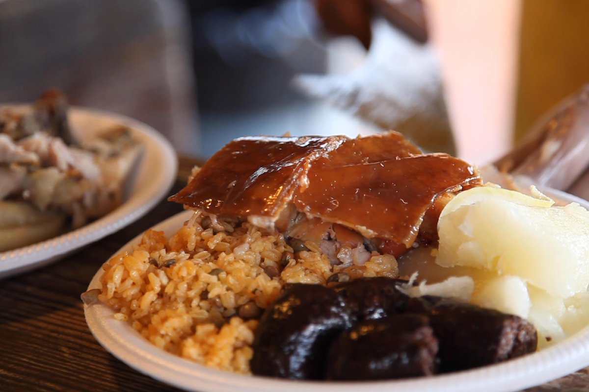 Roasted pork, rice and pigeons peas and morcilla on a dish.