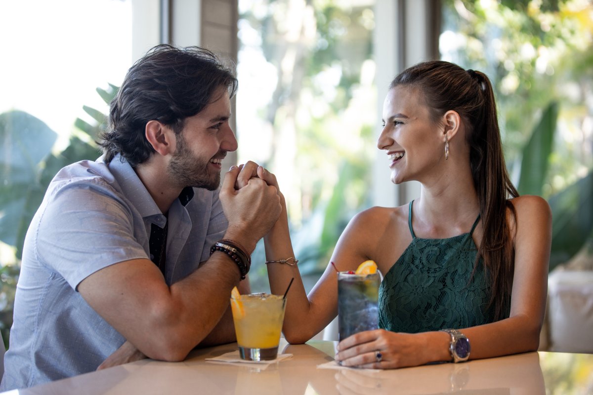 A young couple is enjoying cocktails.
