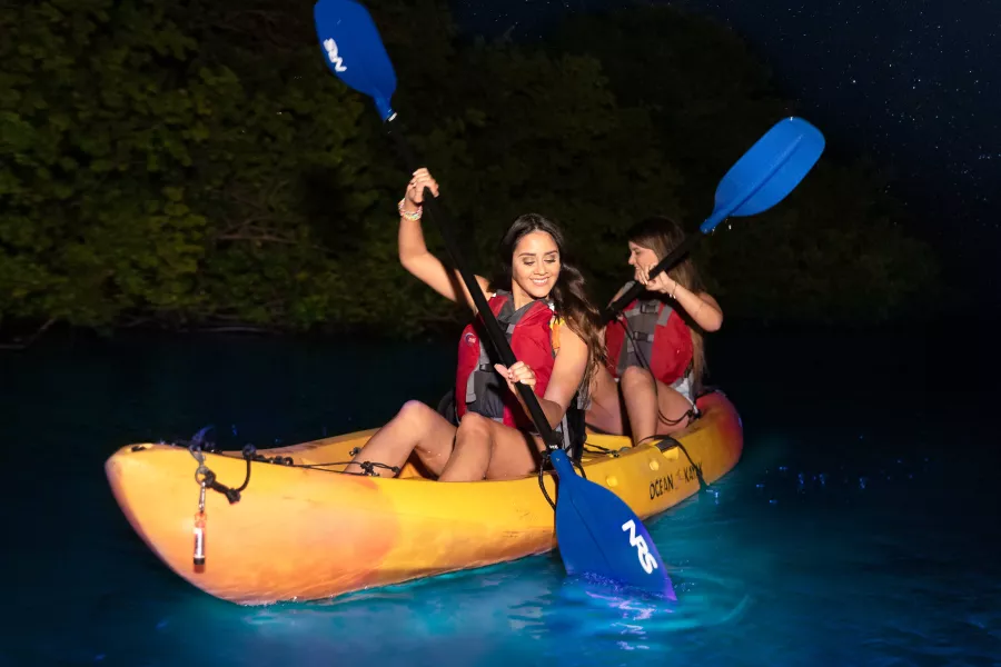 Kayakers paddling through  the glowing waters of Puerto Rico’s Bio Bay at night