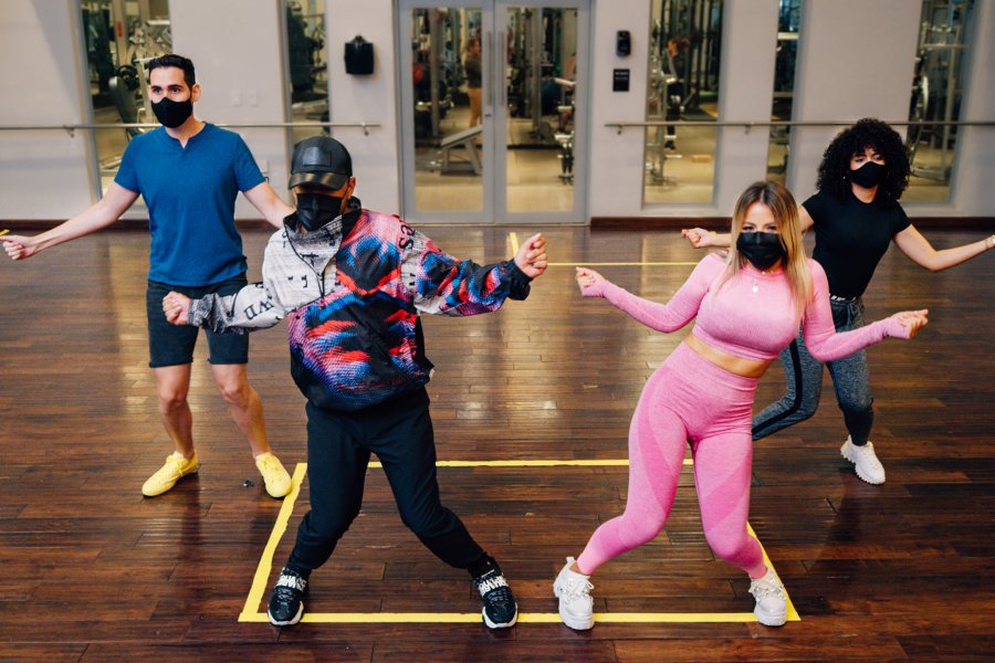 A group of young people learning to dance reggaeton.