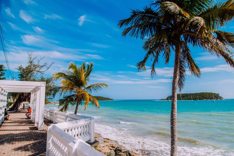 Visitors stroll along a scenic oceanfront walkway in Vieques, Puerto Rico.