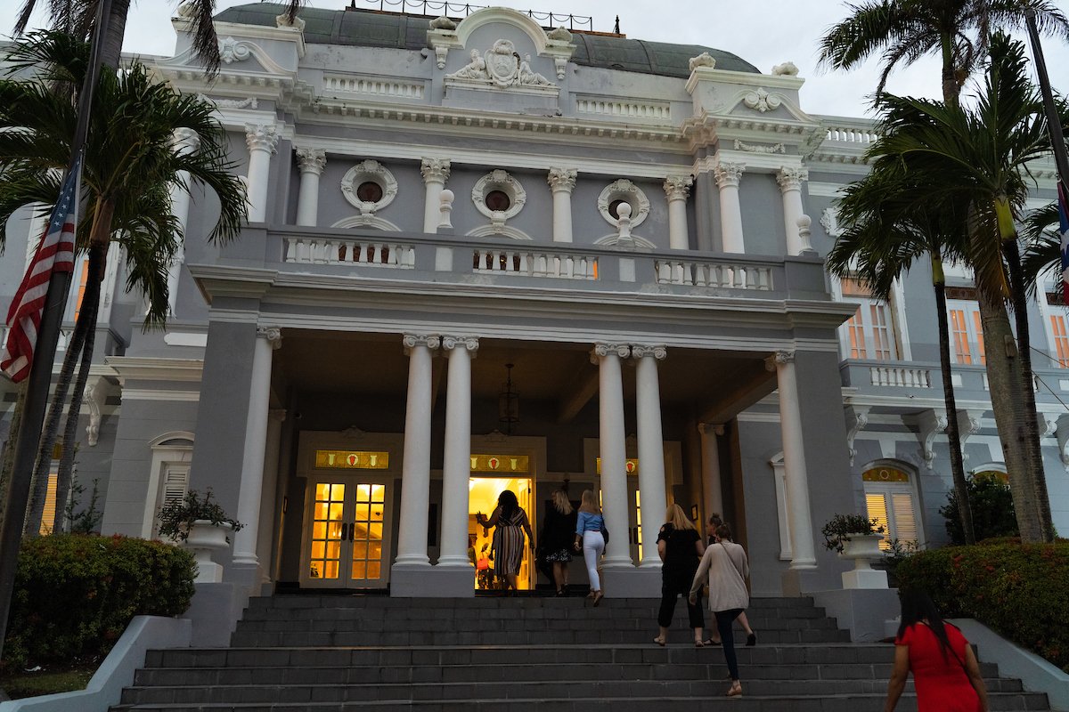 Un grupo de personas ingresa al Antiguo Casino de Puerto Rico para un evento.