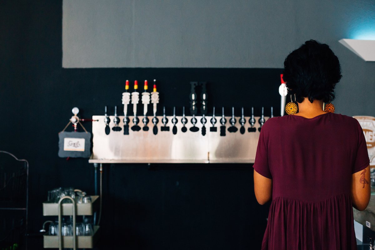 A woman serves an artisanal draft beer at El Grifo restaurant. 