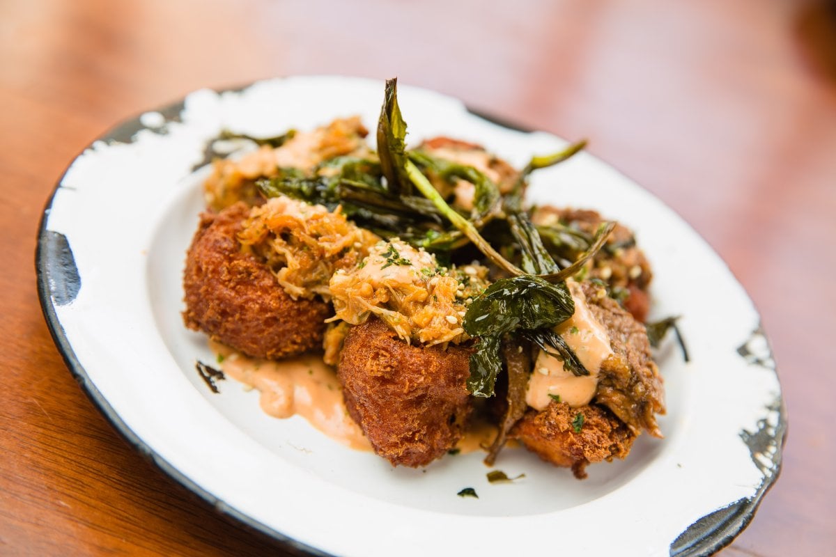 Small plate of Puerto Rican fritters served on a bed of sauce.