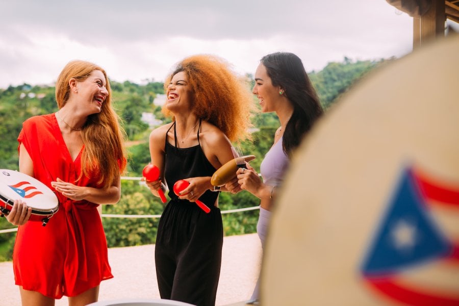 Girls are singing and laughing during a holiday parranda. 