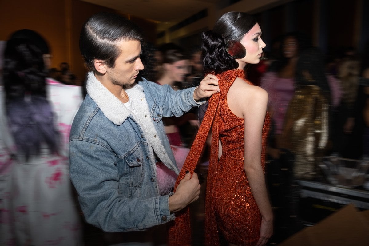 Designer Christian Cowan fixes model dress during New York Fashion Week.