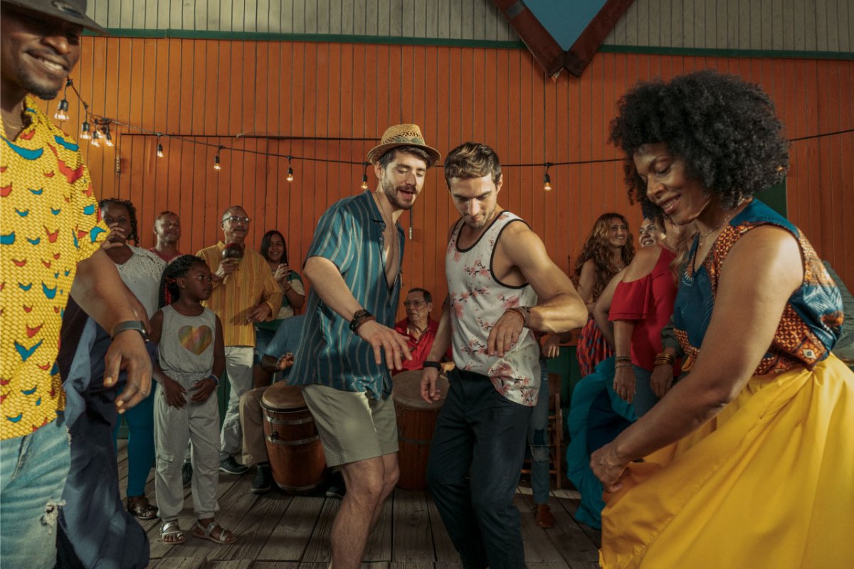 Two men dance with local dancers in Pinones, Puerto Rico