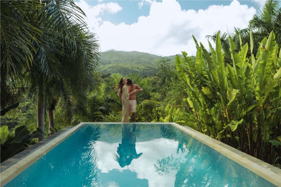 A couple embraces at the edge of an infinity pool in Rio Grande, Puerto Rico