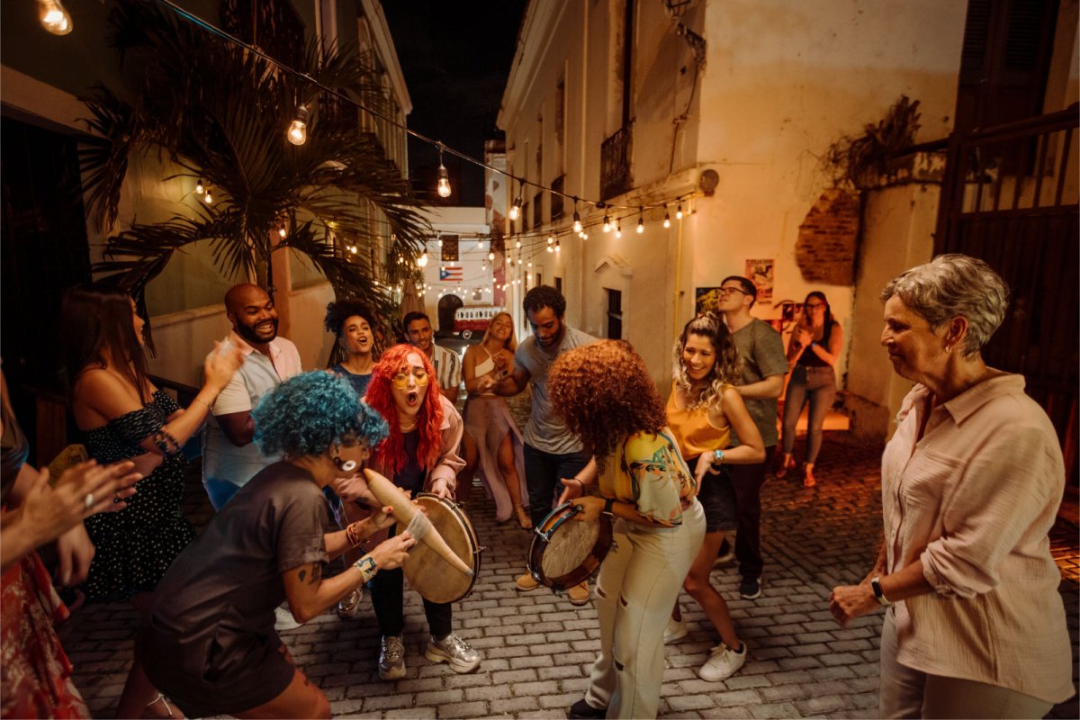 A group of people dance and play music in a street in Old San Juan, Puerto Rico