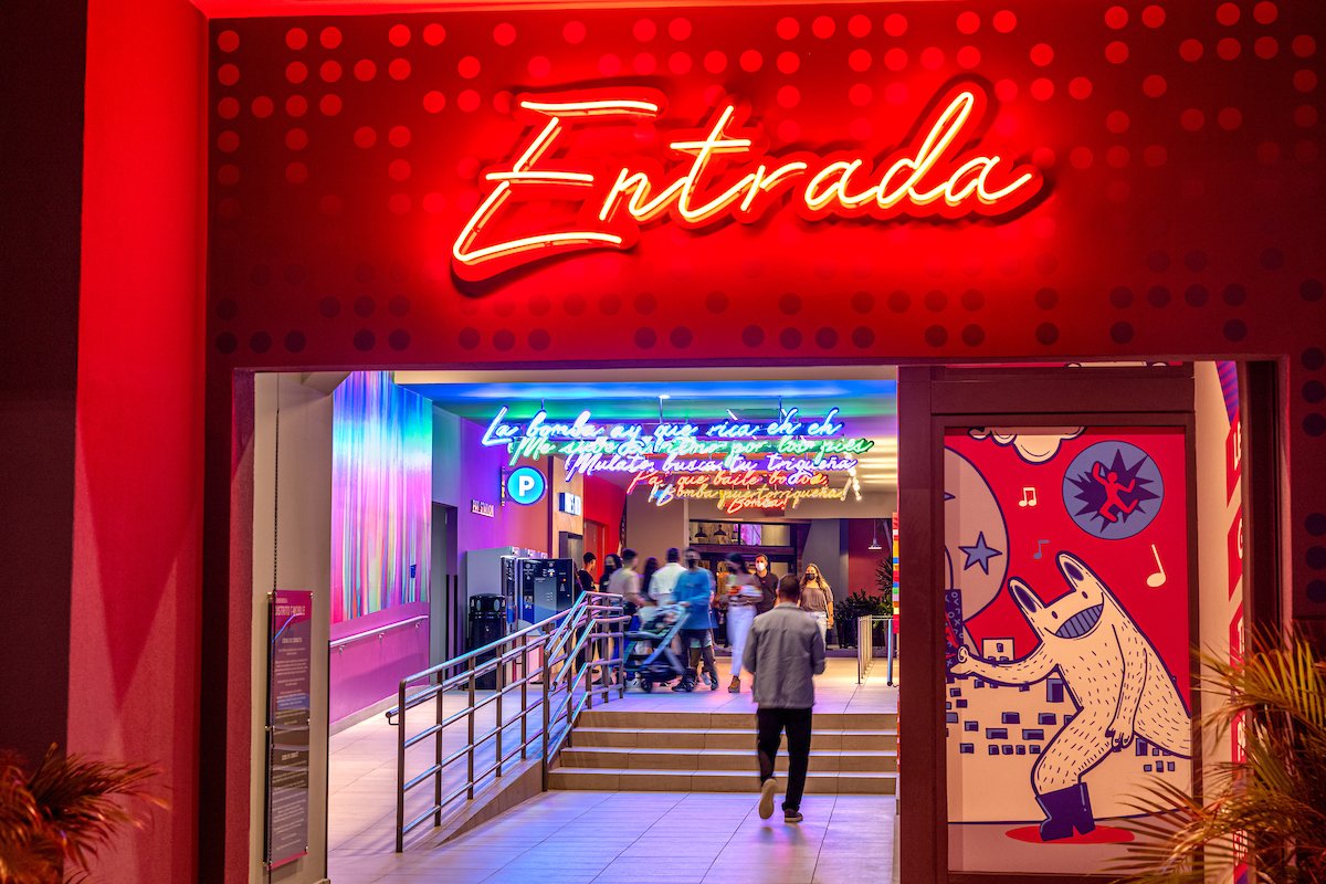 Neon signs in multiple colors light an entrance to Distrito T-Mobile