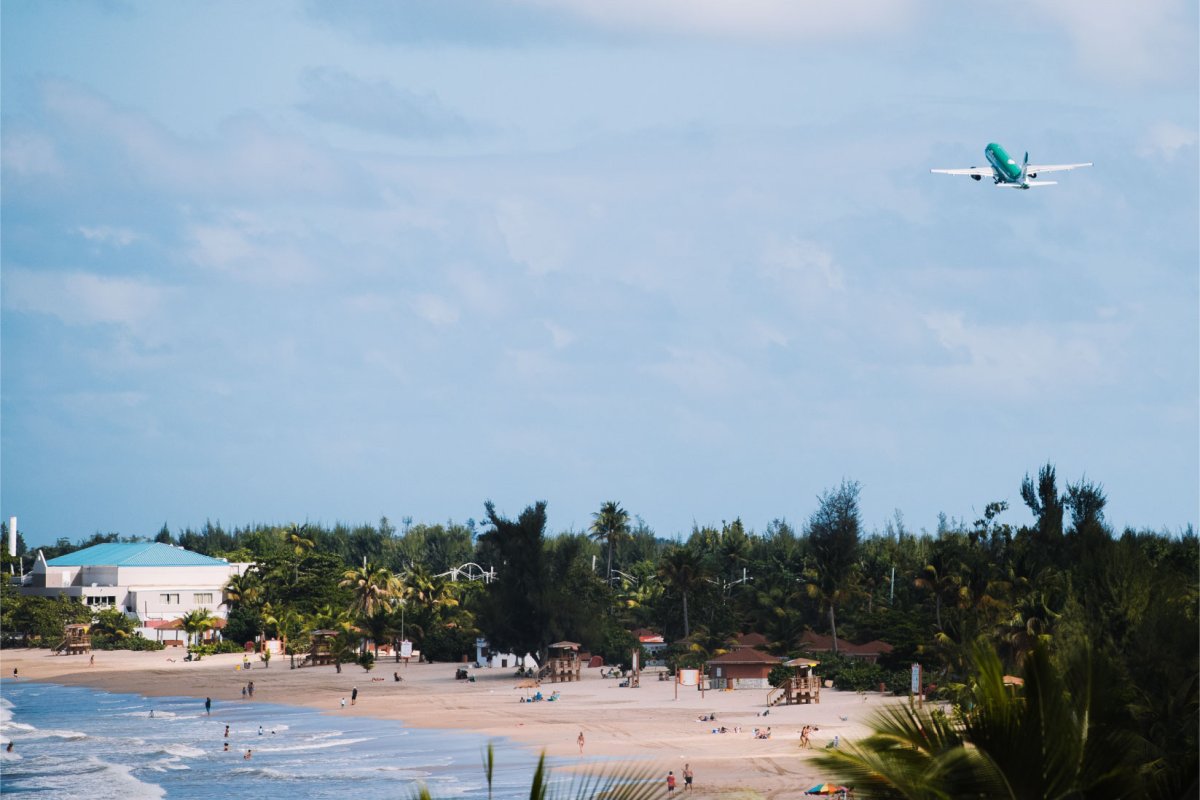 An airplane flies over a beach in Carolina, Puerto Rico