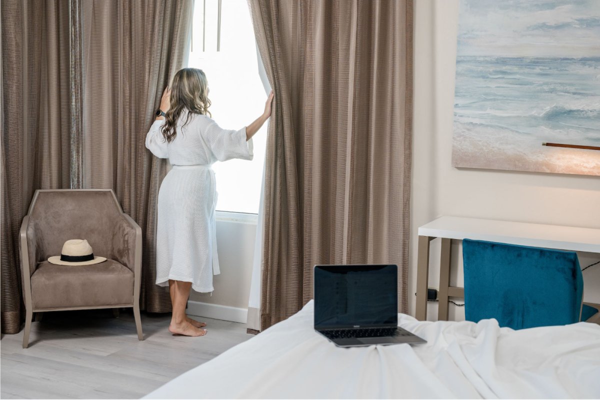 A woman stands in her guest room at the Vendanza Hotel in Puerto Rico, looking out the window.