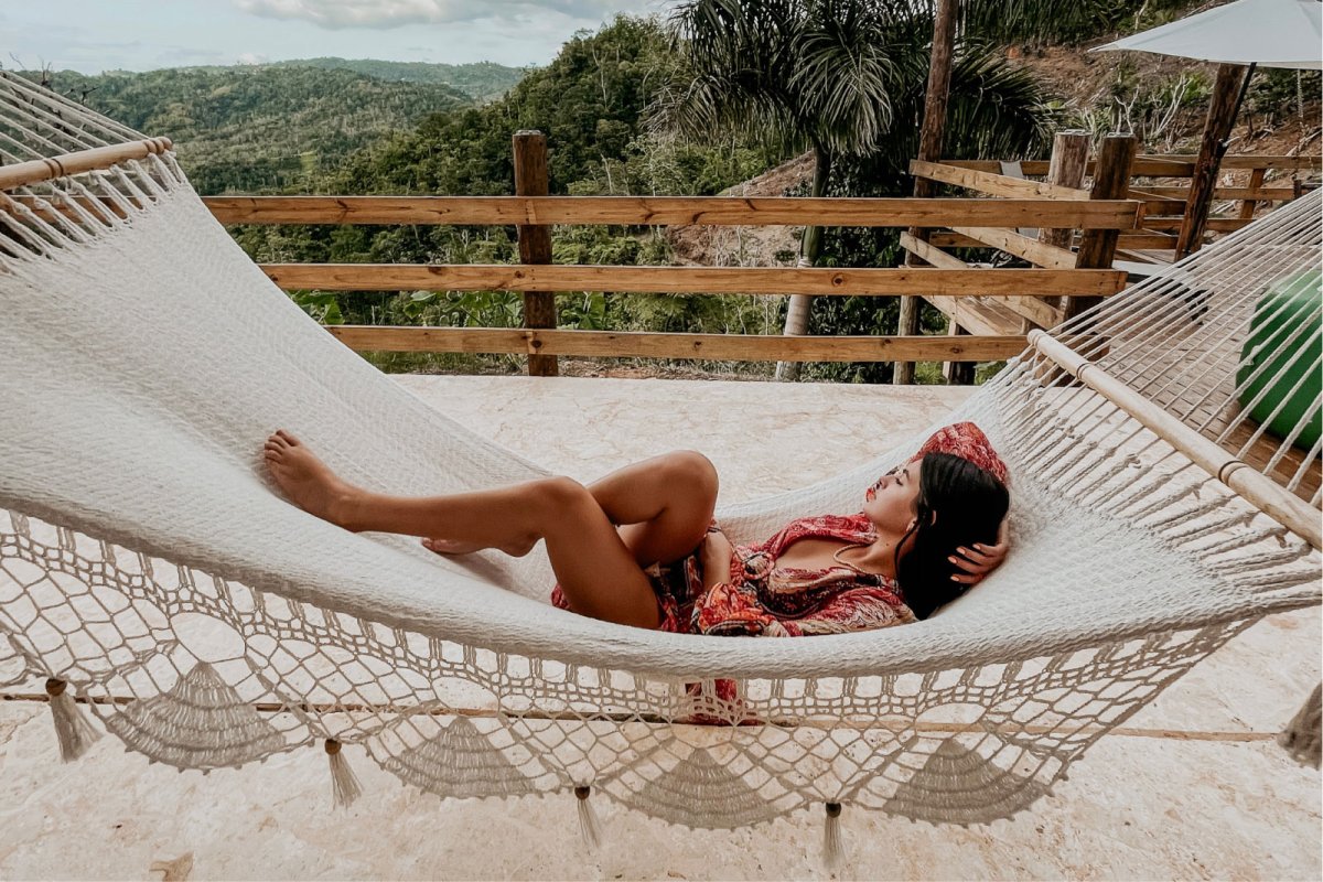 A woman relaxes in a hammock overlooking the Central Mountains in Puerto Rico.
