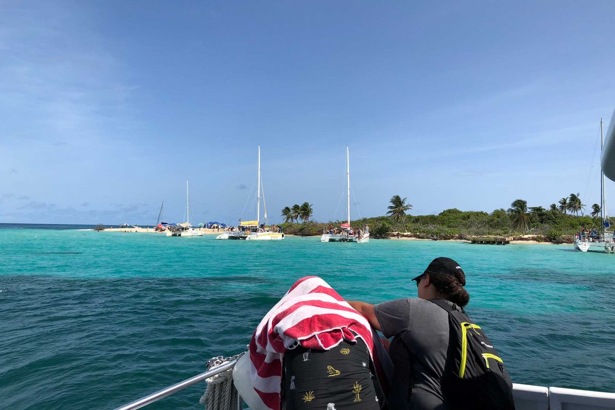 Two people ride a boat to Icacos Island.