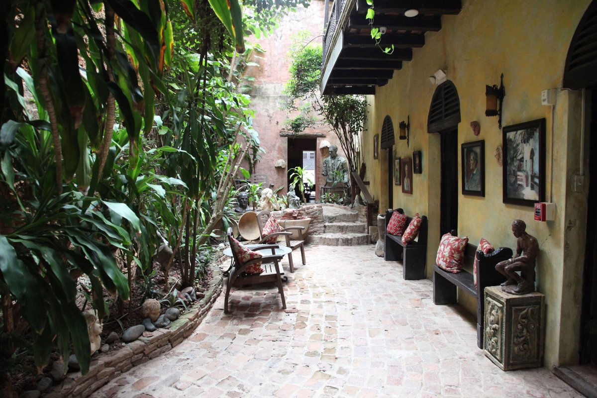 Quaint courtyard of the Gallery Inn, which features a cobblestone walkway and tropical foliage.
