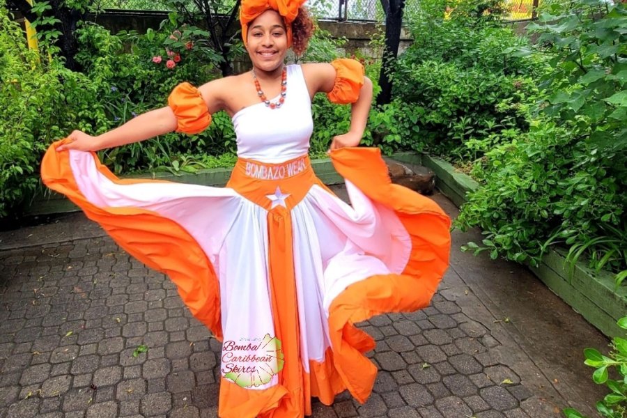 A woman in traditional bomba garb displays her skirt in shades of Puerto Rico Sunshine.
