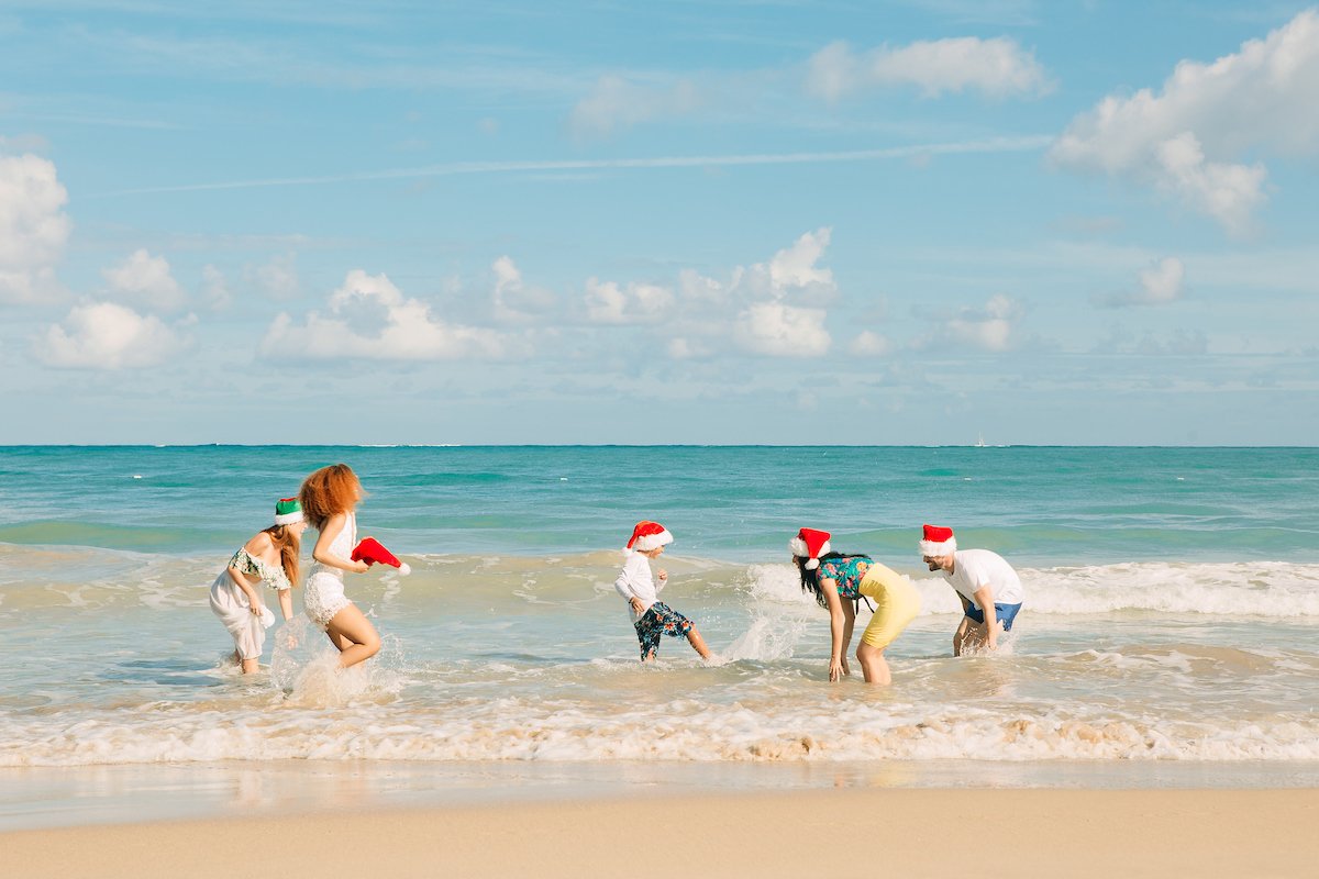 A family plays at the beach during Christmas time. 