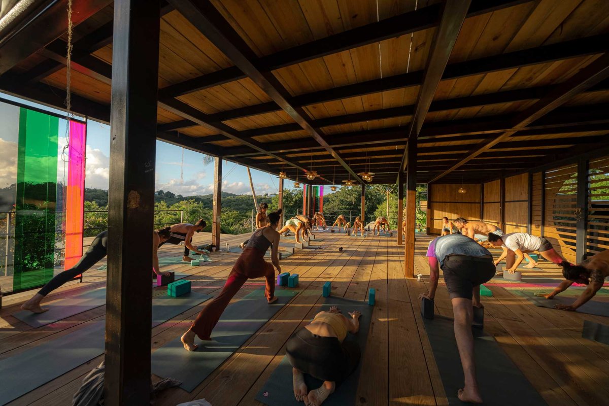 A group practices yoga in a wooden yoga studio at Finca Victoria in Vieques, Puerto Rico.