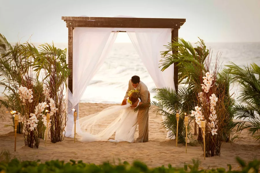 A newly married couple kisses on the beach at a destination wedding in San Juan, Puerto Rico.