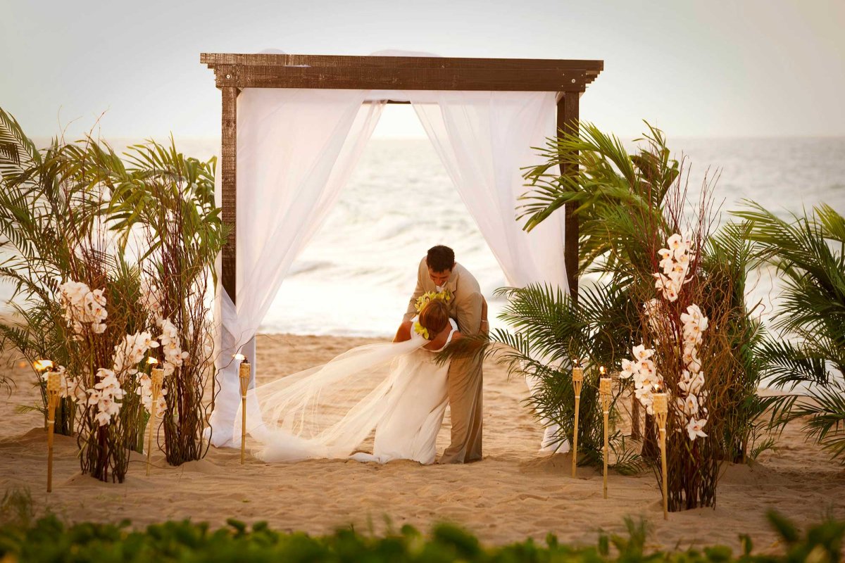 A newly married couple kisses on the beach at a destination wedding in San Juan, Puerto Rico.