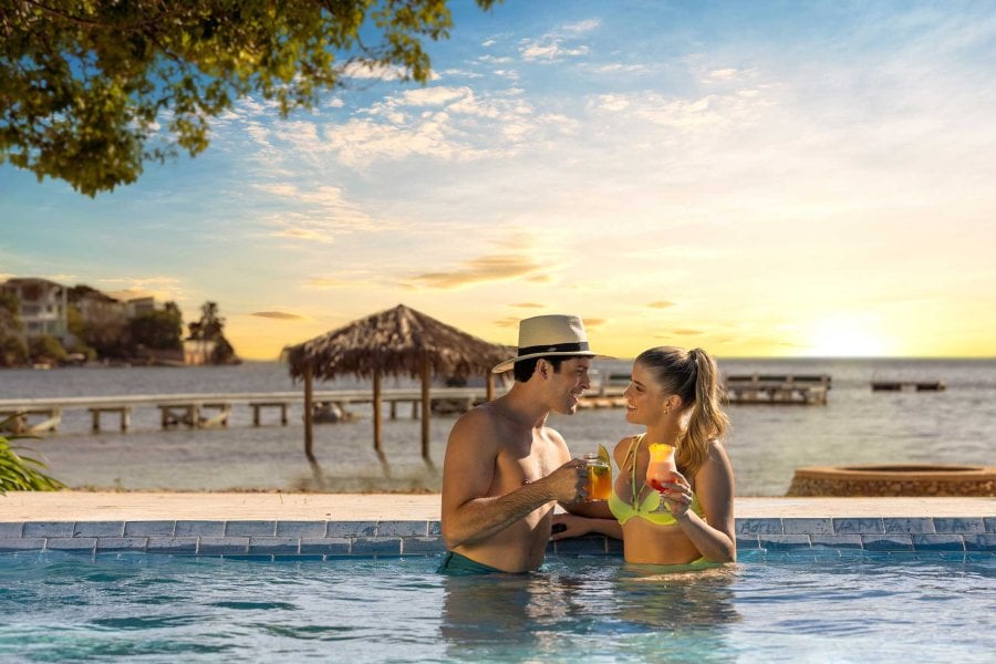 A couple sips tropical drinks in a pool at the Copamarina Beach Resort & Spa in Guánica, Puerto Rico.