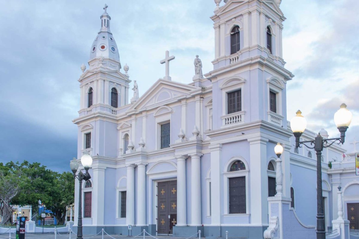Catedral de Nuestra Señora de Guadalupe in Ponce, a dramatic white church, stands against a twilight sky.