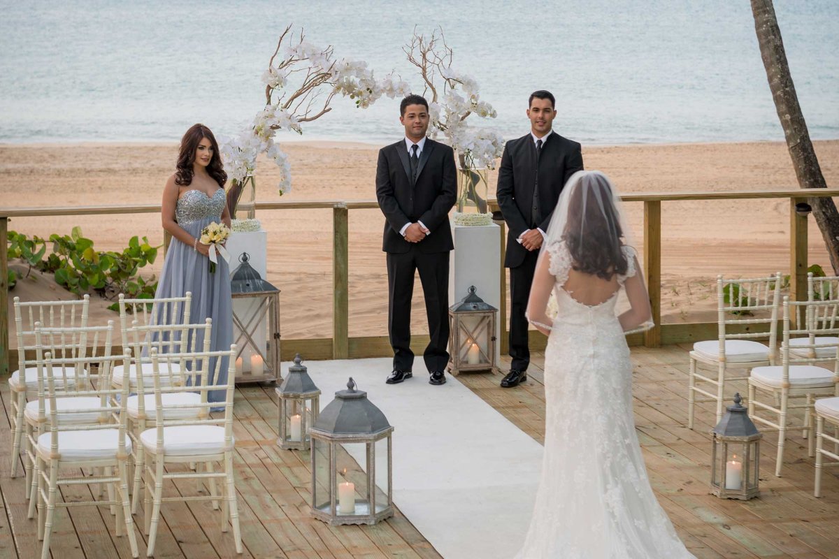 A bride walks down the aisle during a small wedding at the Wyndham Grand Rio Mar Puerto Rico Golf & Beach Resort.
