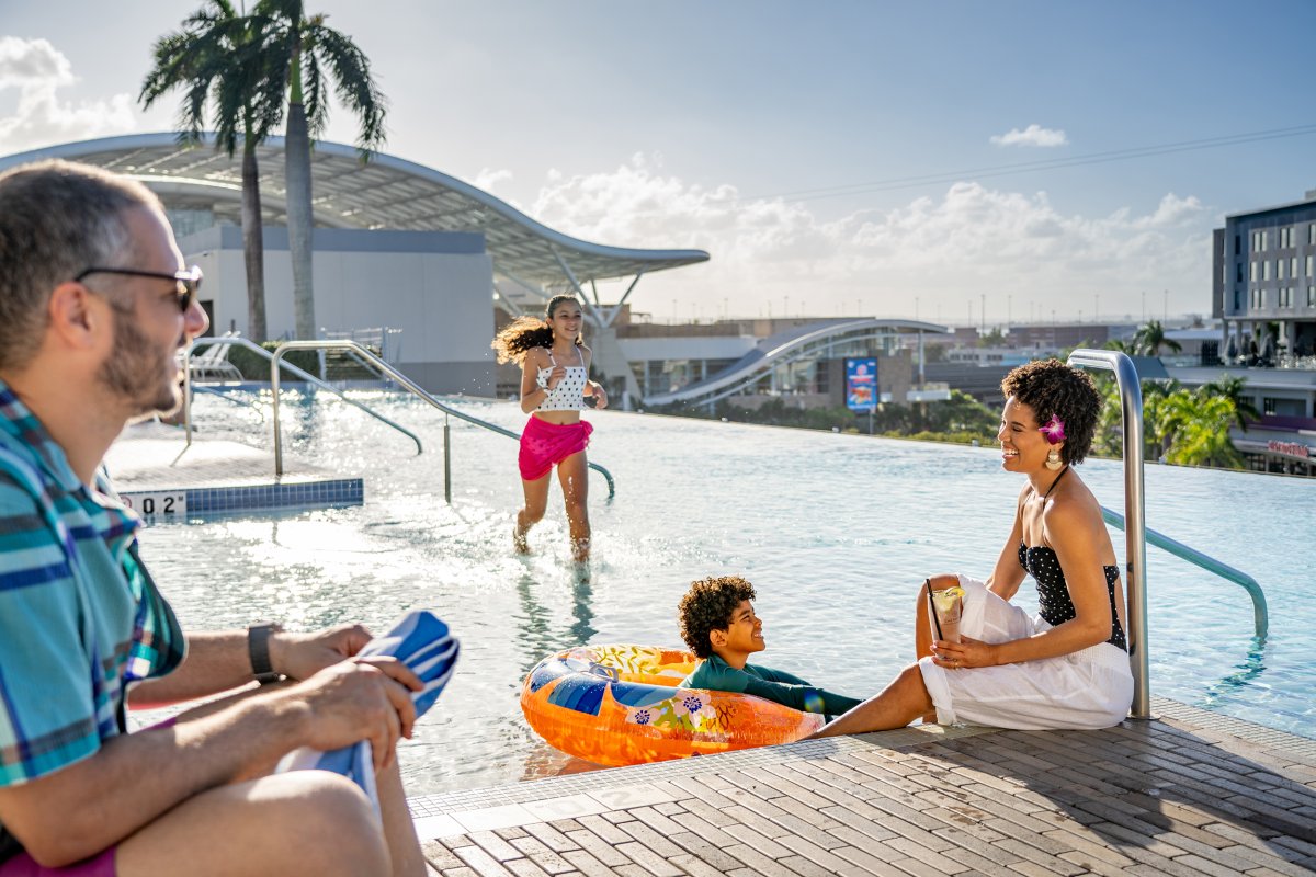 Familia con niños jugando en una piscina.
