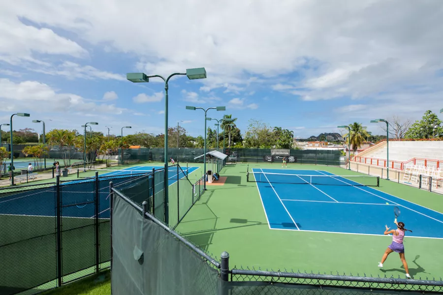 Dos mujeres compitiendo en un partido de tenis individual en el Honda Tennis Center de Bayamón, Puerto Rico.