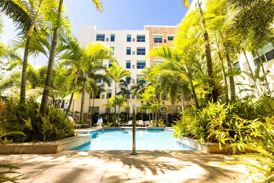 Piscina al aire libre rodeada de palmeras en el Hyatt House San Juan, Puerto Rico.
