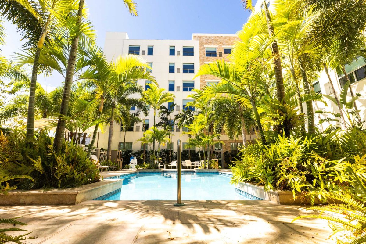 Outdoor swimming pool surrounded by palm trees at the Hyatt House San Juan, Puerto Rico.