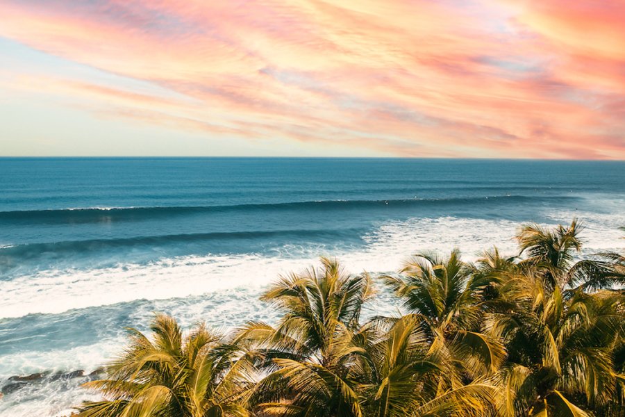 The sun setting, painting the sky a color of orange and pink, over the pristine waters of the beaches in Aguadilla, Puerto Rico.
