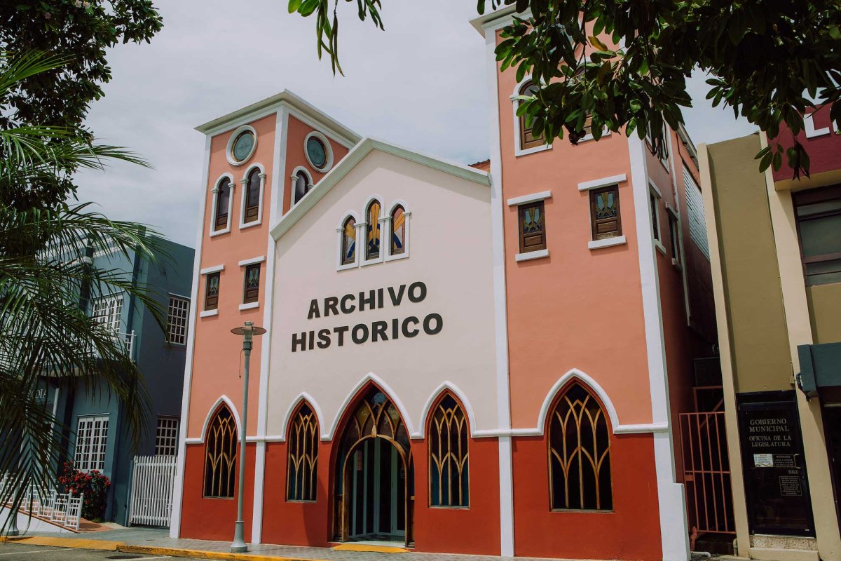 A historic building painted in pink, white and red, houses the Archivo Historico in San Sebastián, Puerto Rico.