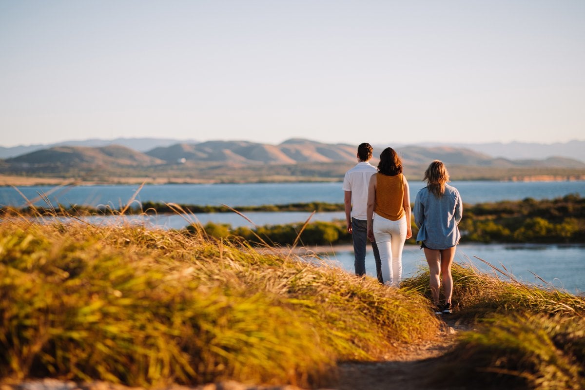 Familia de tres personas caminando por la costa del Bosque Nacional Cabo Rojo.