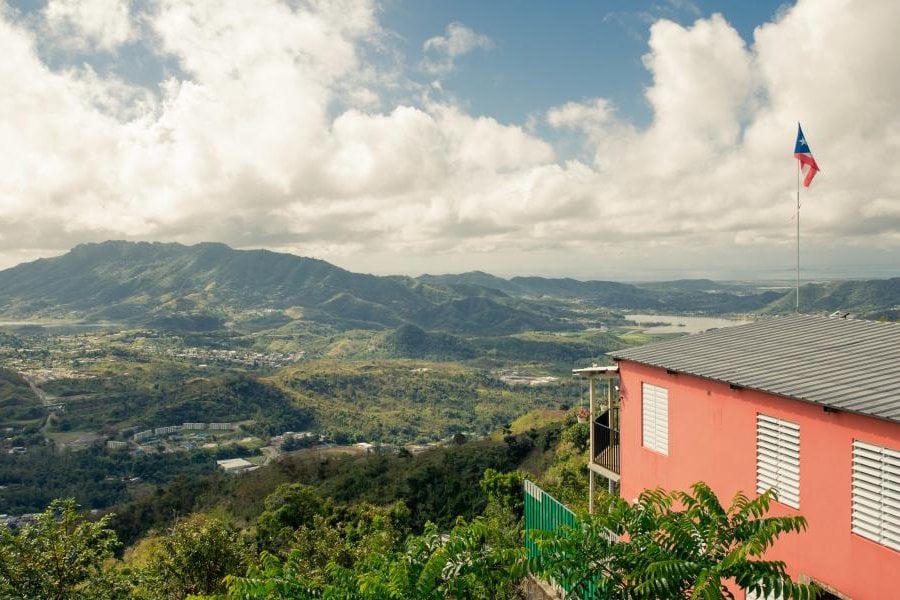 Aerial shot of a house perched over mountains.