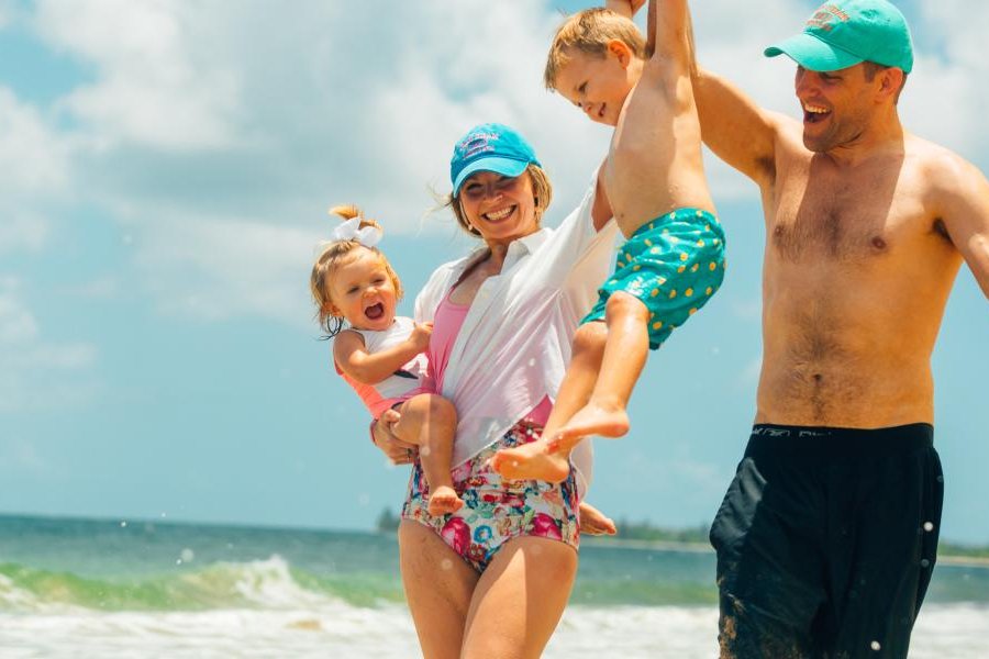Family of four playing on a beach.