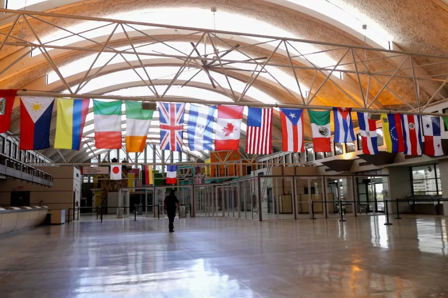 A hallway of an airport with multiple flag banners in Puerto Rico.