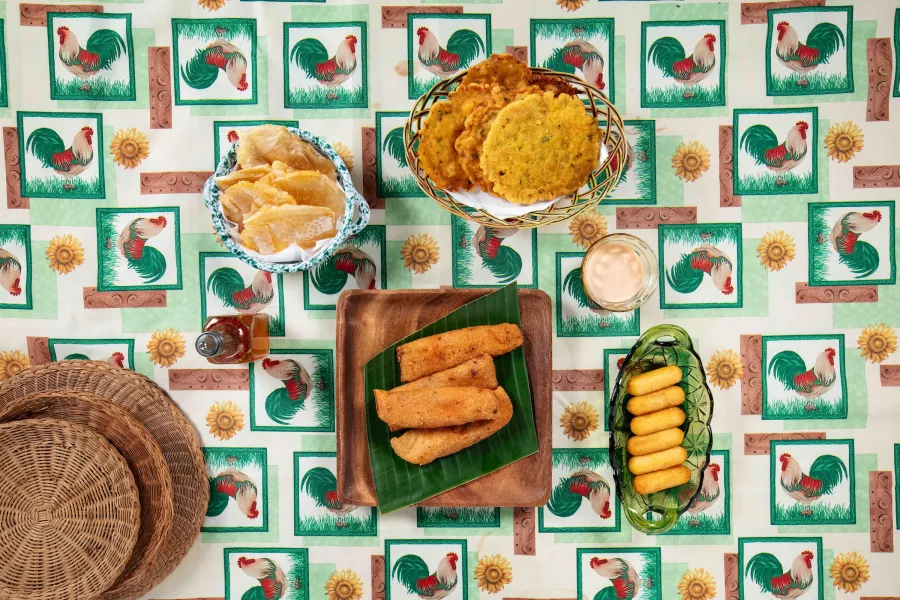 Traditional Puerto Rican fritters and snacks served on a table with a colorful patterned tablecloth.