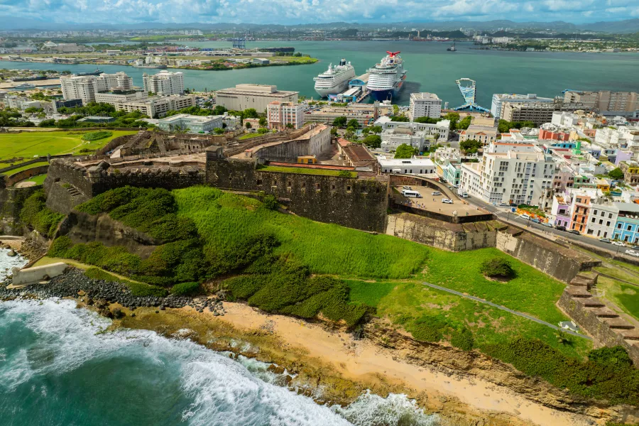 Aerial view of Castillo San Cristóbal in Old San Juan, with its large stone walls overlooking the coastline and city.