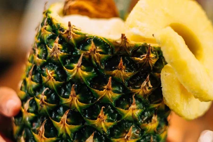 A freshly carved pineapple filled with fruit.