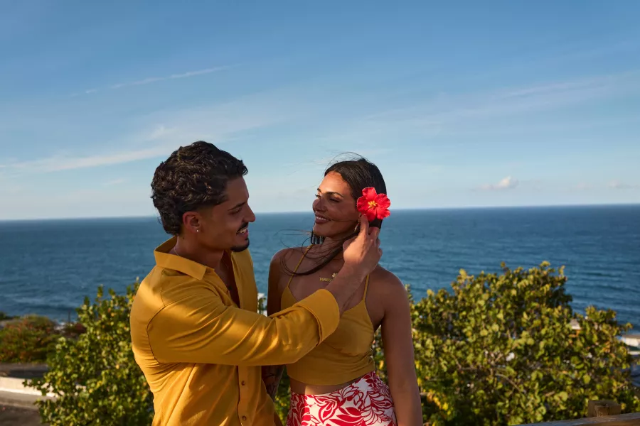 Man putting a flower in a woman's hair.