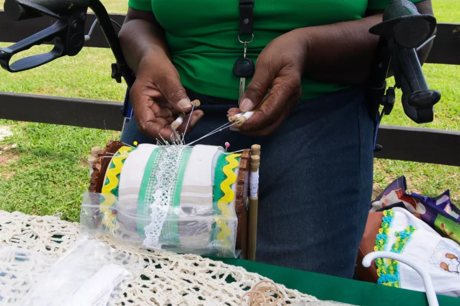 Puerto Rican artisan creating traditional mundillo lace using wooden bobbins and cotton thread. Generations of artisans have preserved the art of mundillo lace-making on the Island.