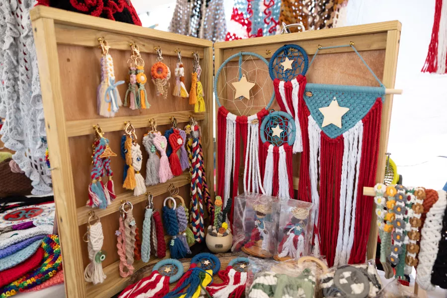 Exhibición de artesanías textiles, llaveros y piezas decorativas hechas a mano por artesanos puertorriqueños en una feria artesanal local.