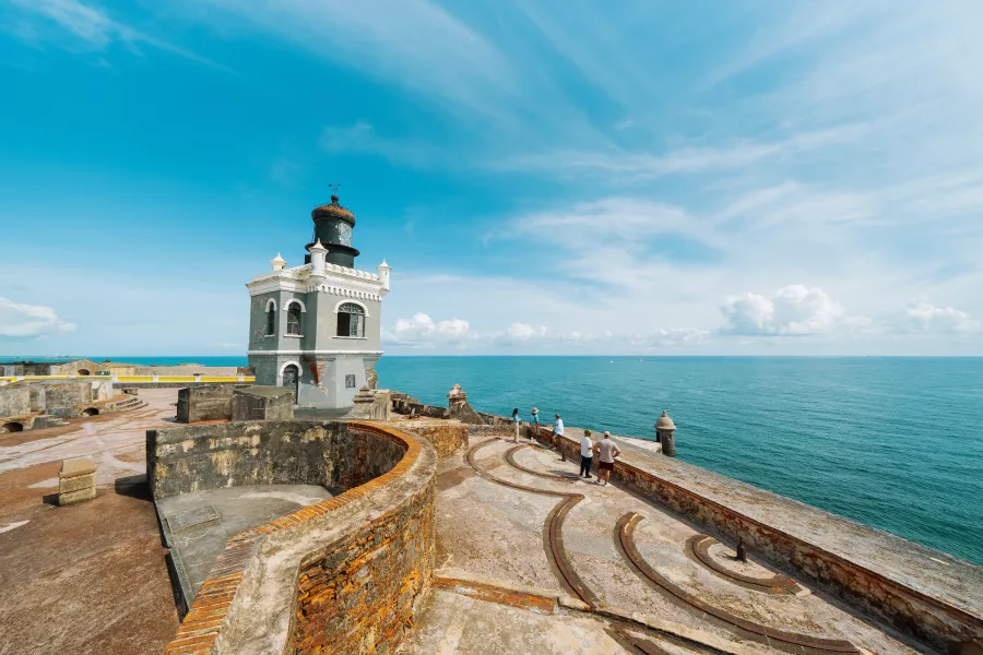 Visitors admire the Atlantic Ocean from El Morro's historic ramparts in Old San Juan, Puerto Rico.