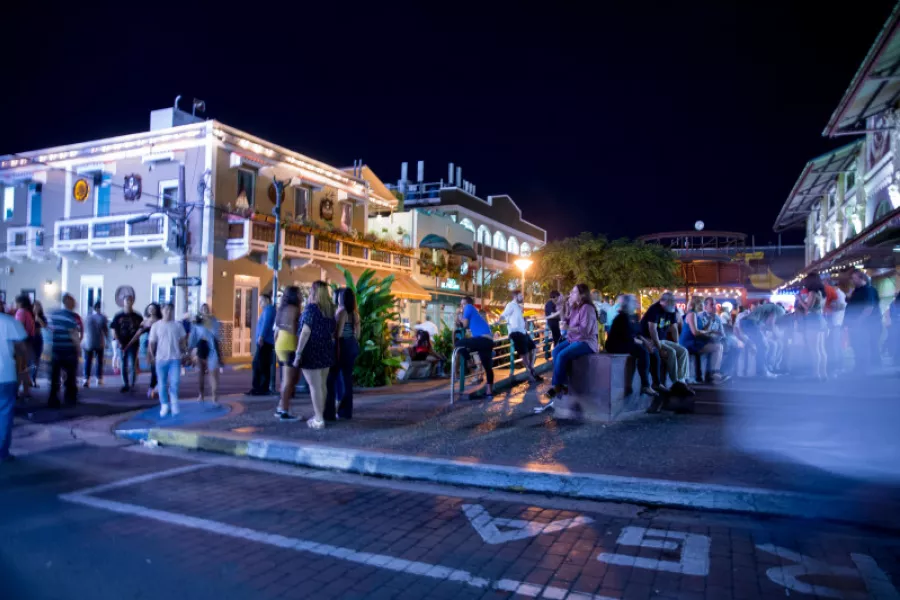 Nighttime view of La Placita de Santurce in San Juan, with people gathering around the plaza, illuminated restaurants and bars, and the lively atmosphere that defines the district after dark.