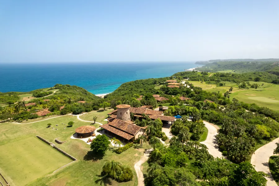 Vista aérea de las instalaciones de Royal Isabela, rodeadas de exuberante vegetación y con vistas al océano Atlántico.