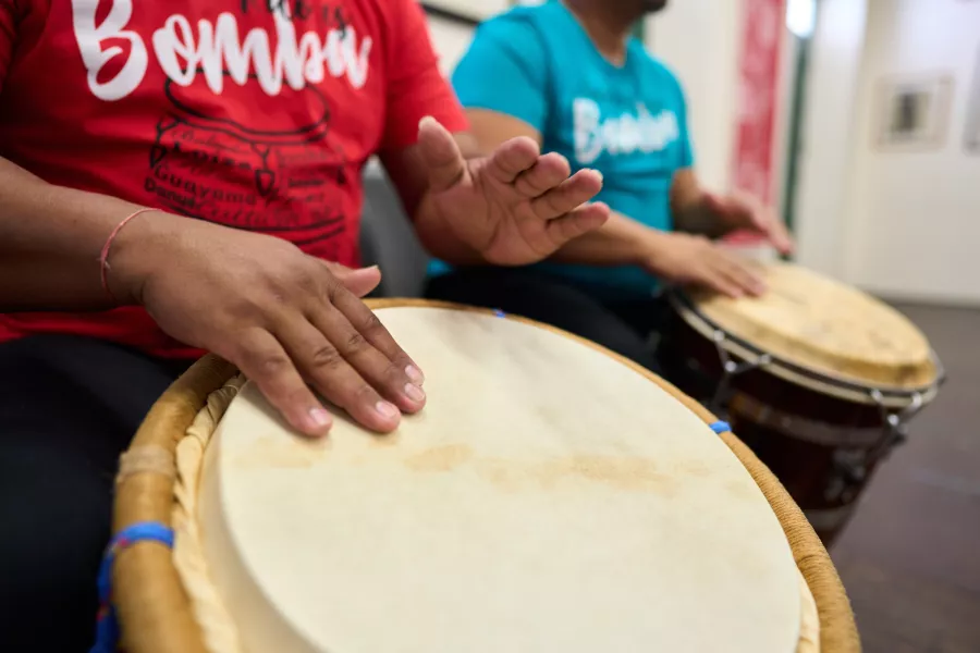 Close-up of musicians playing barril drums during a bomba performance, a musical tradition rooted in Puerto Rico's African heritage.