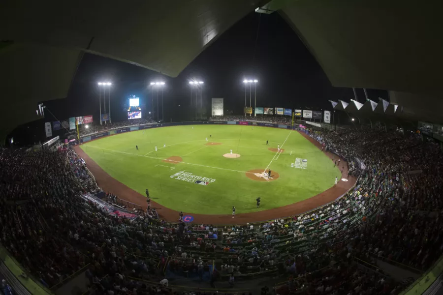 Night view of Hiram Bithorn Stadium in San Juan filled with fans during a baseball game.
