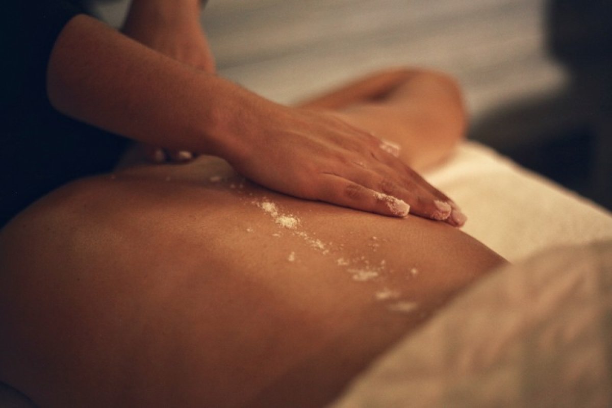 A massage therapist performs a massage on a client's back at Nouvelle D'Spa.