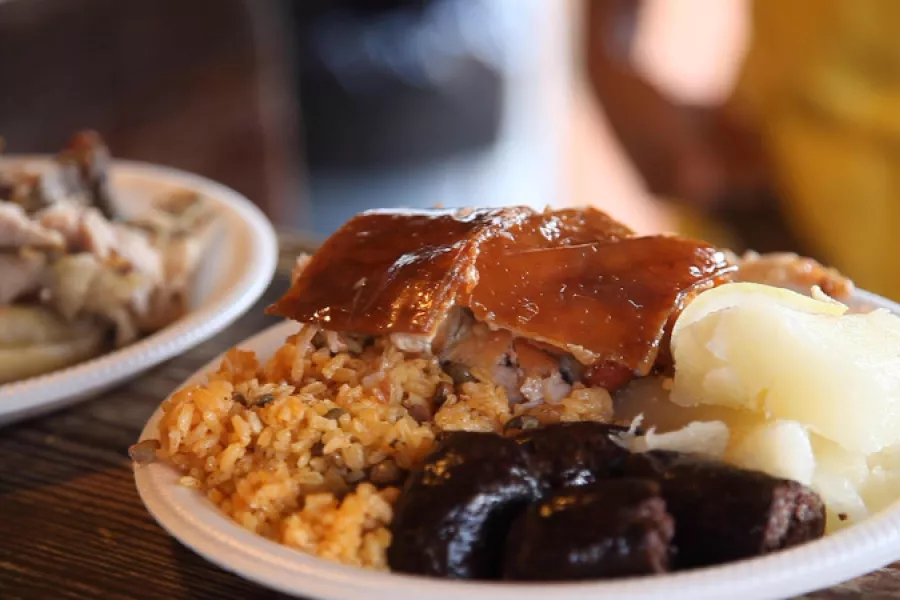View of a traditional Puerto Rican holiday dish filled with rice and pigeon peas and lechón asado.